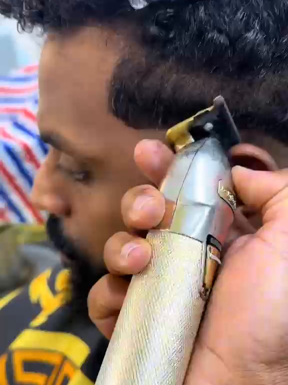 Barber detailing a fade with clippers
